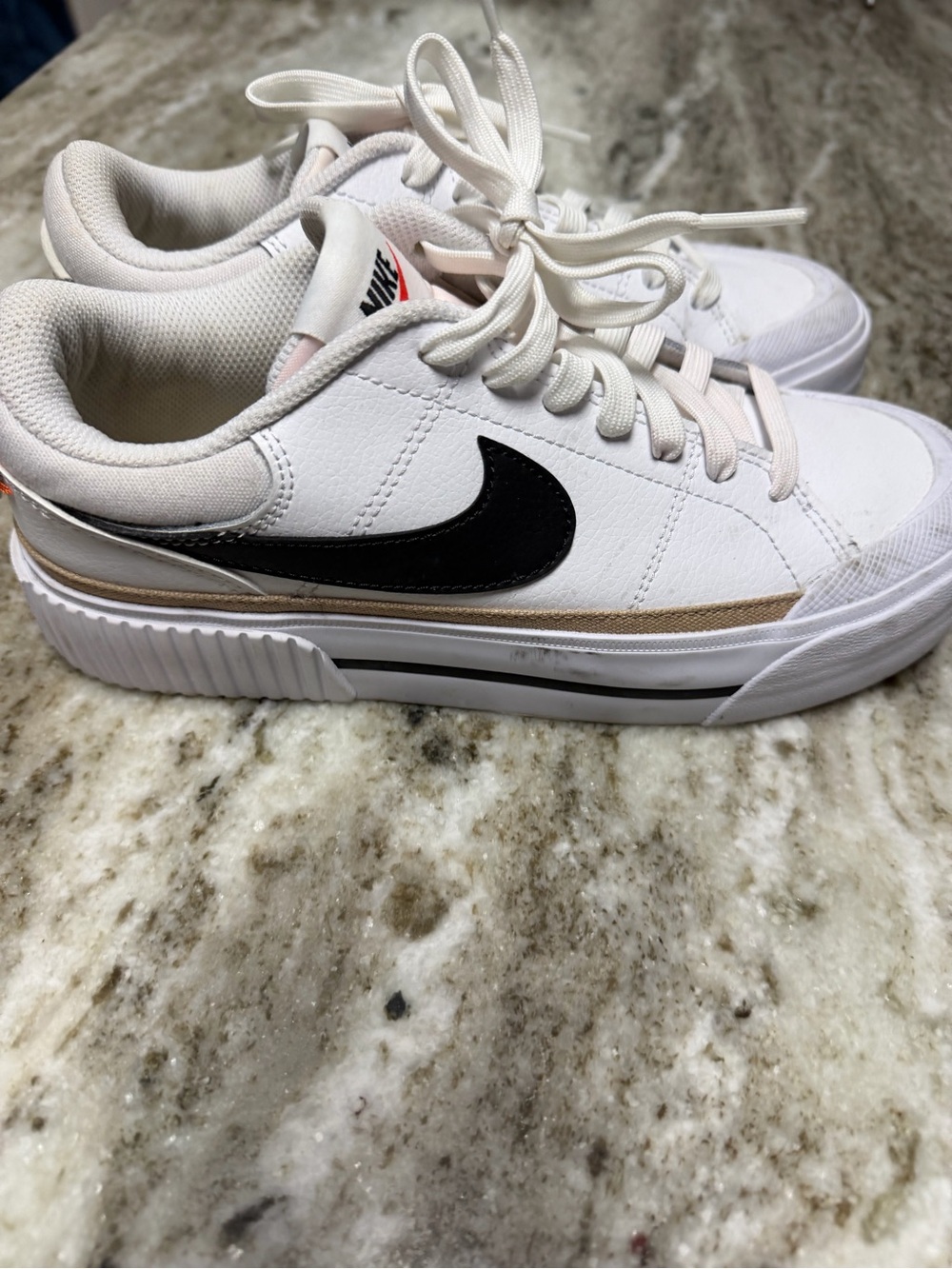 Nike Women's White Sneakers with Black Swoosh and Gold Accent